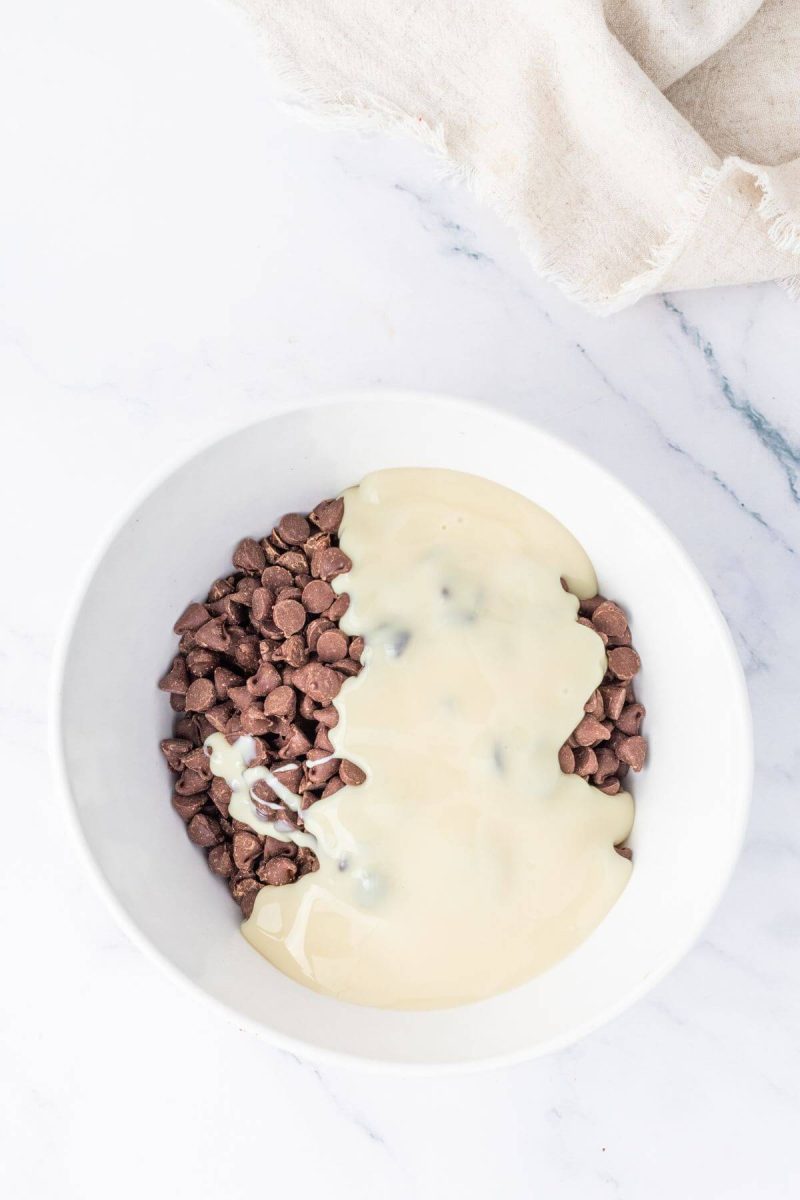Chocolate chips with sweetened condensed milk in microwave safe bowl for fudge.