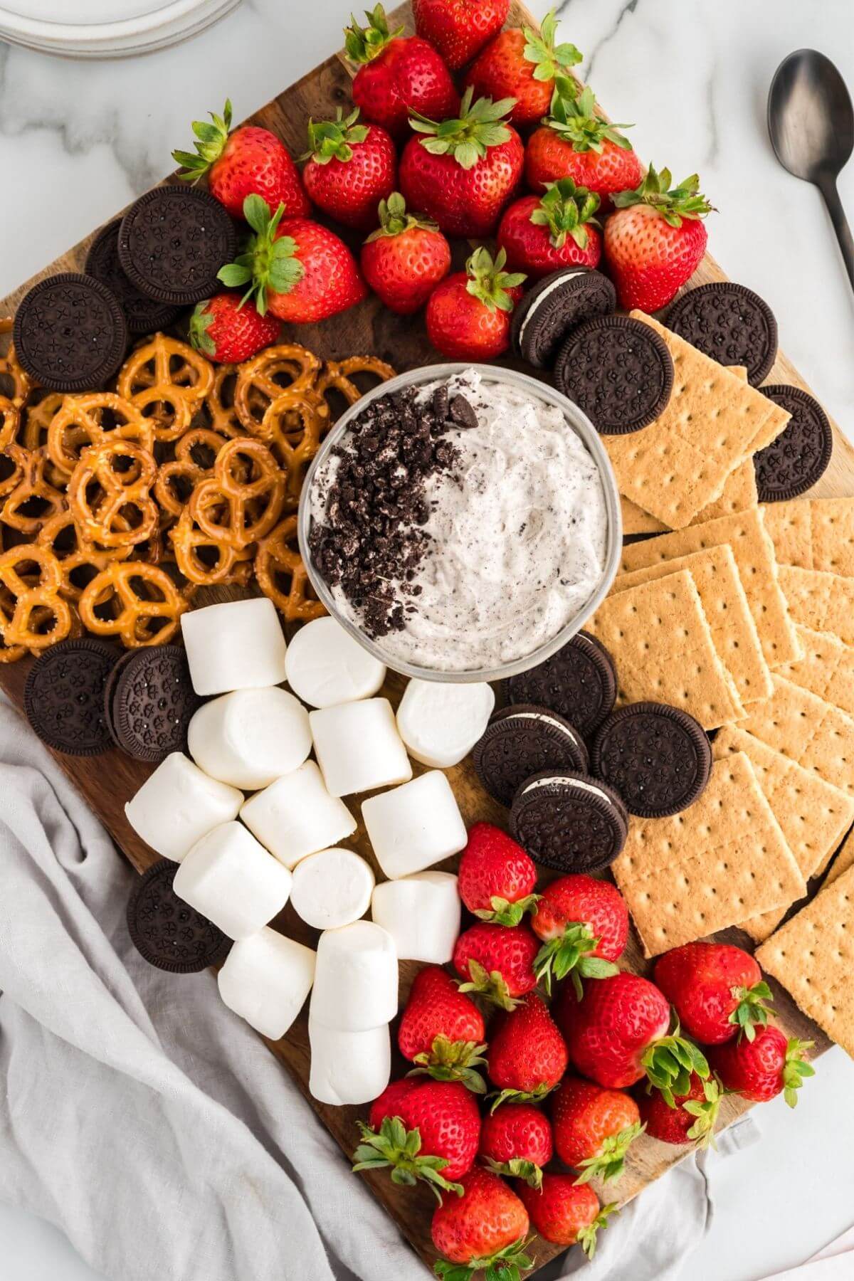 Oreo fluff dessert dip in a bowl served with pretzels, marshmallows, graham crackers, strawberries and more Oreo cookies.