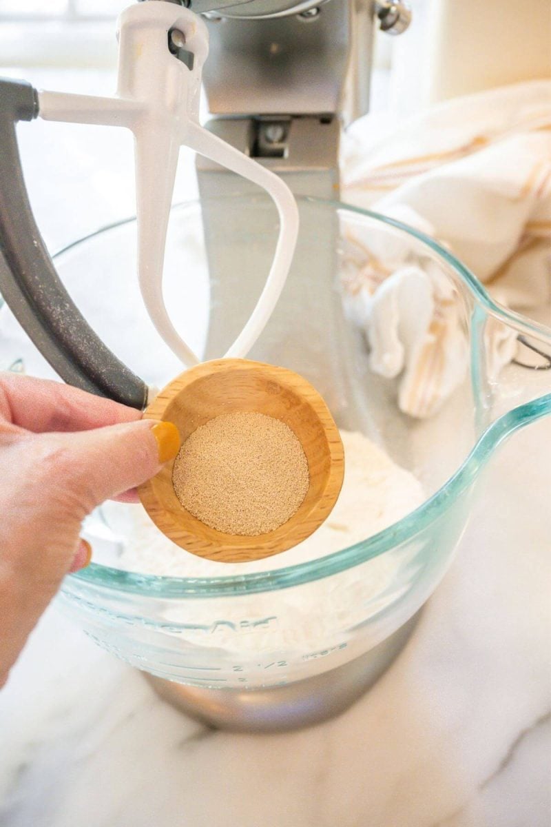 Adding yeast to the bread flour for the cinnamon roll dough. 