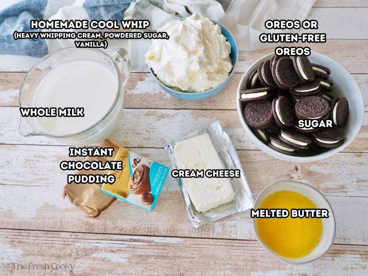 Labeled ingredients for Oreo Pudding Dessert. L-R: Cold milk, instant chocolate pudding, homemade cool whip, cream cheese, Oreos, and butter.