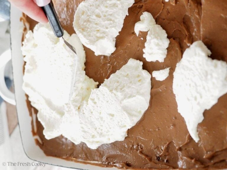 Spreading final homemade Cool Whip on top of the pudding layer.