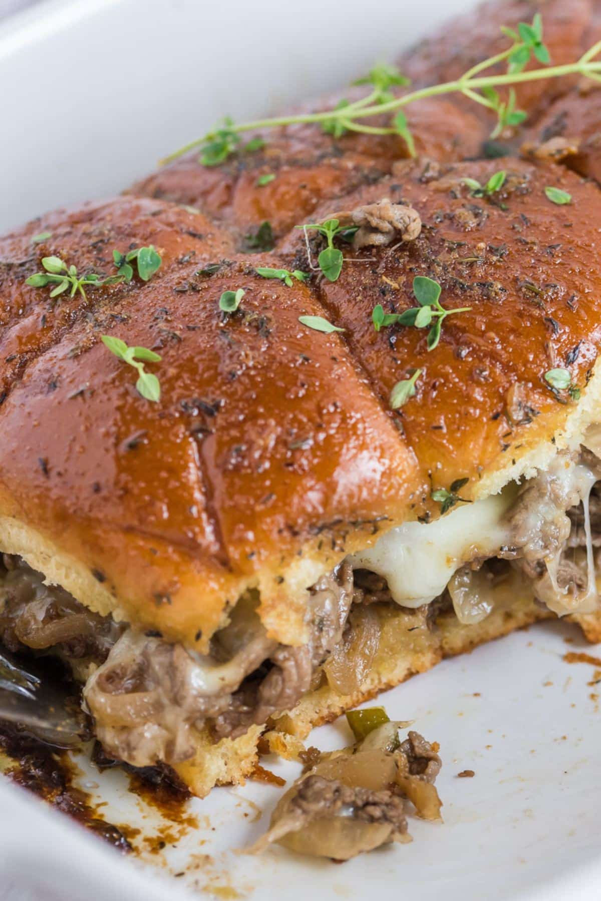 Close up of tender Philly Cheesesteak sliders with melty cheese, tender onions and peppers.