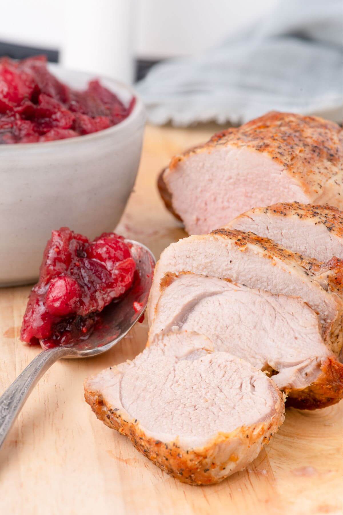 Pork Tenderloin with Date and Cranberry Chutney in spoon by the side.