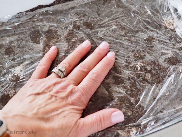 Hand patting Oreo Cookie crust into 9x13 inch pan.