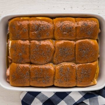 Sauce poured over the top of the sliders and then sprinkled with poppy seeds.