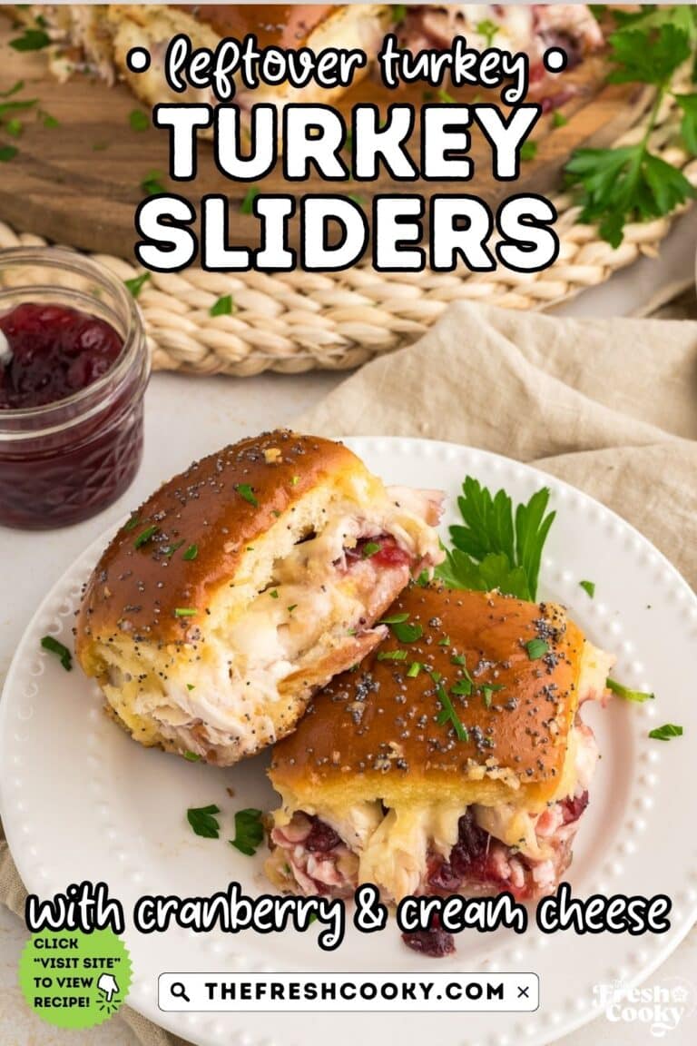 Two turkey and cranberry cream cheese sliders on a white plate, to pin.