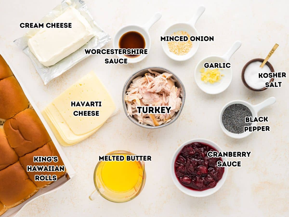 Turkey and cheese slider labeled ingredients. L-R Cream cheese, worcestershire sauce, onion flakes, minced garlic, salt, pepper, cranberry sauce, melted butter, leftover turkey, havarti cheese and Hawaiian rolls.