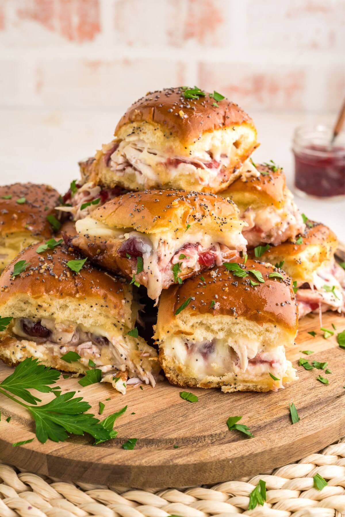 Closer view of pile of baked turkey sliders recipe with parsley accents.