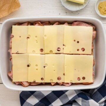 Swiss cheese added to the tops of the ham sliders.