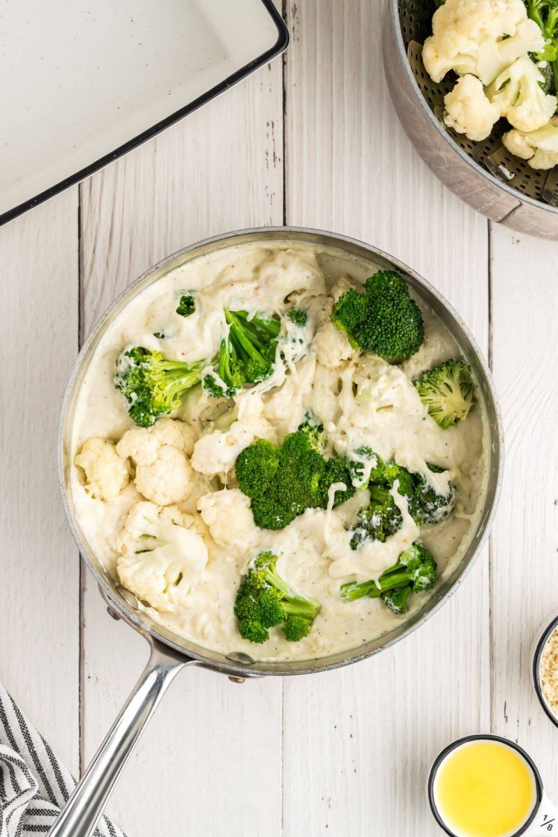 Add steamed broccoli and cauliflower to the cheese mixture in pan. 