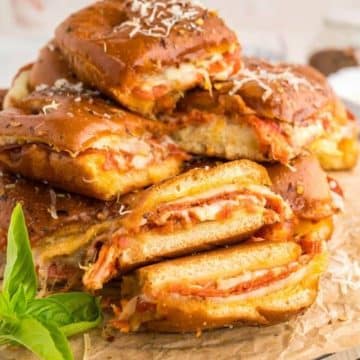 Make ahead pizza sliders stacked and on a tray.