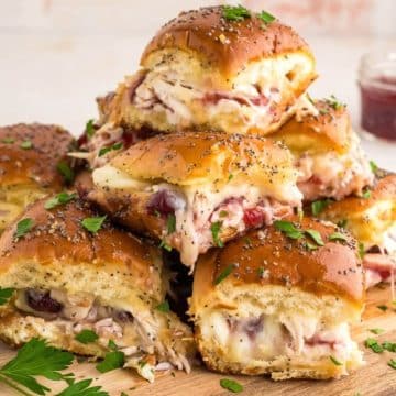 Closer view of pile of baked turkey sliders recipe with parsley accents.