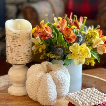 Fall vignette on wooden tray with candle, fresh fall flowers, soft pumpkin and coasters.