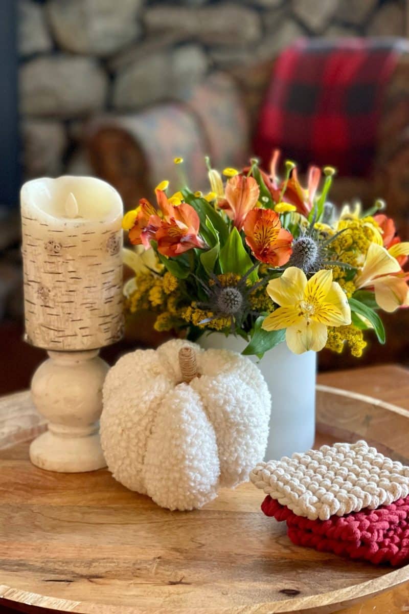 Fall vignette on wooden tray with candle, fresh fall flowers, soft pumpkin and coasters. 