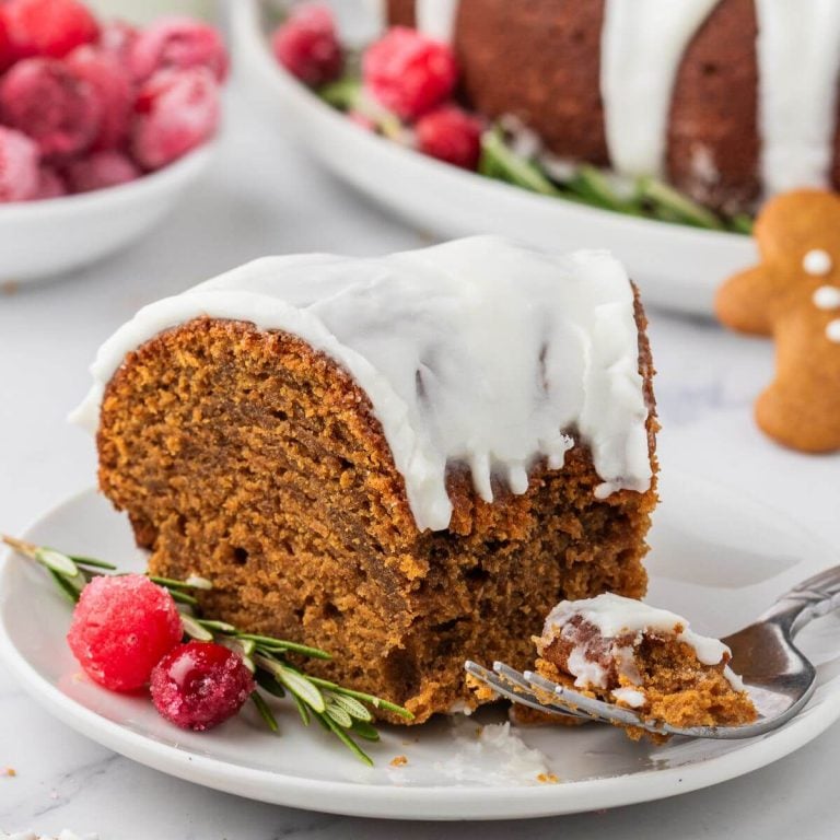 Slice of moist gingerbread bundt cake on plate.