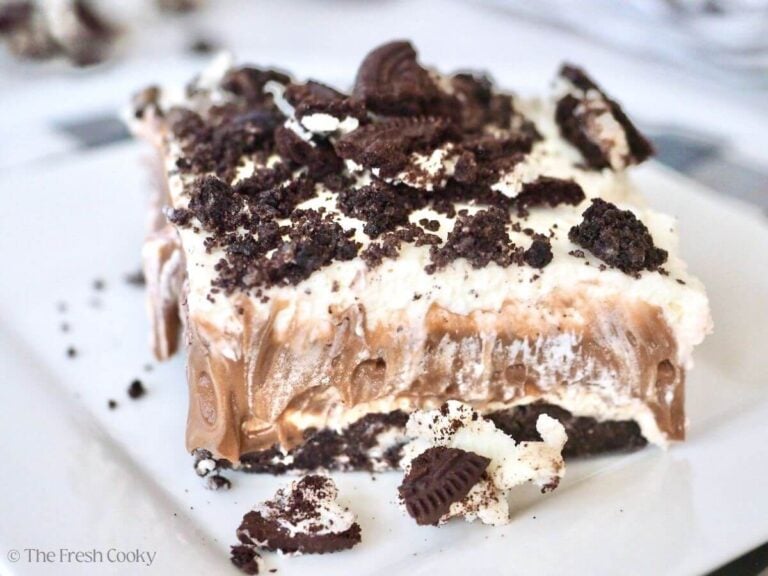 A layered slice of Oreo cookie pudding dessert on white plate.