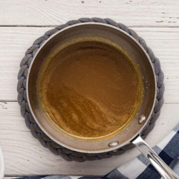 Buttery sauce in saucepan for ham sliders.