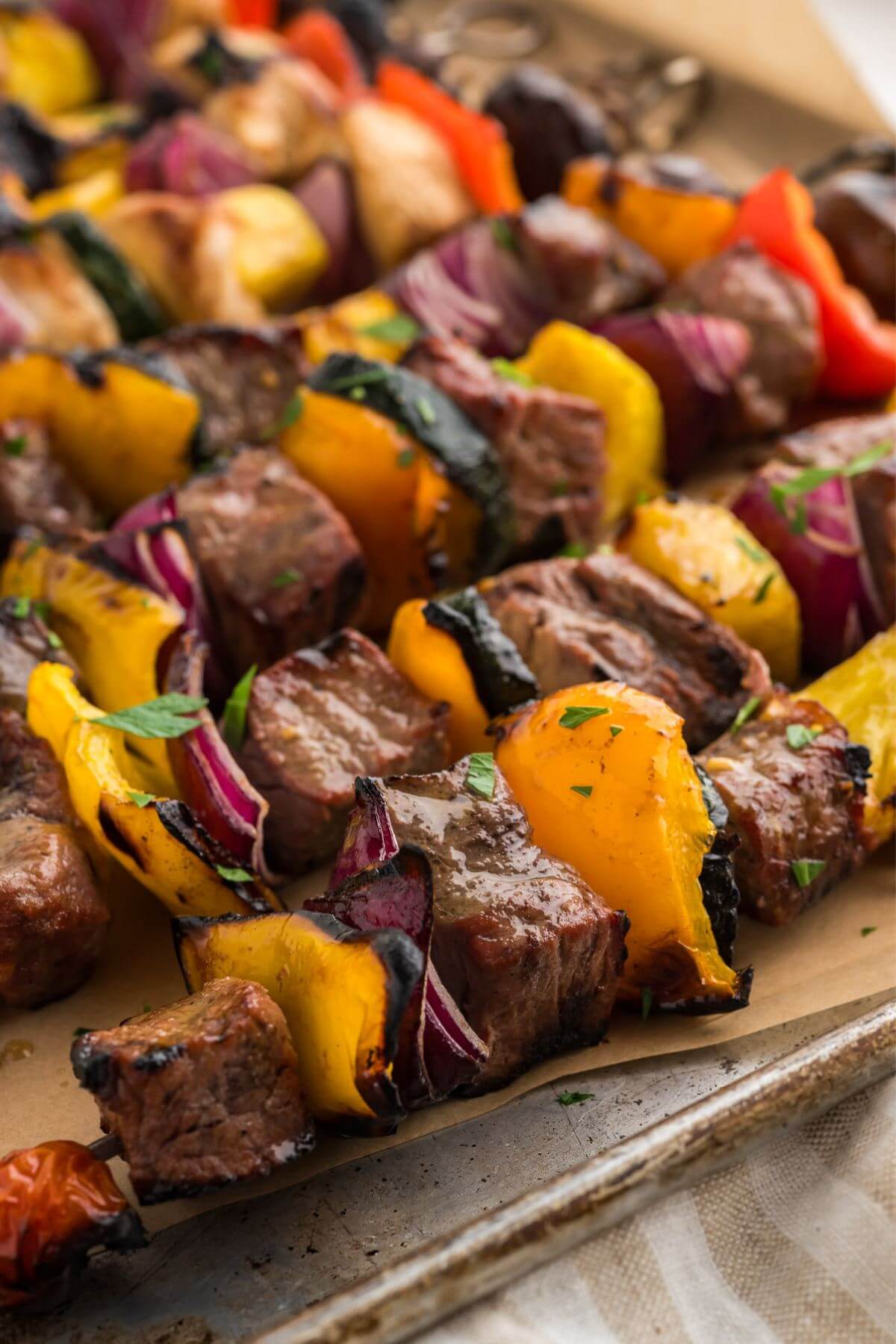 Close up shot of cooked shish kabobs with marinated steak and brightly colored veggies.