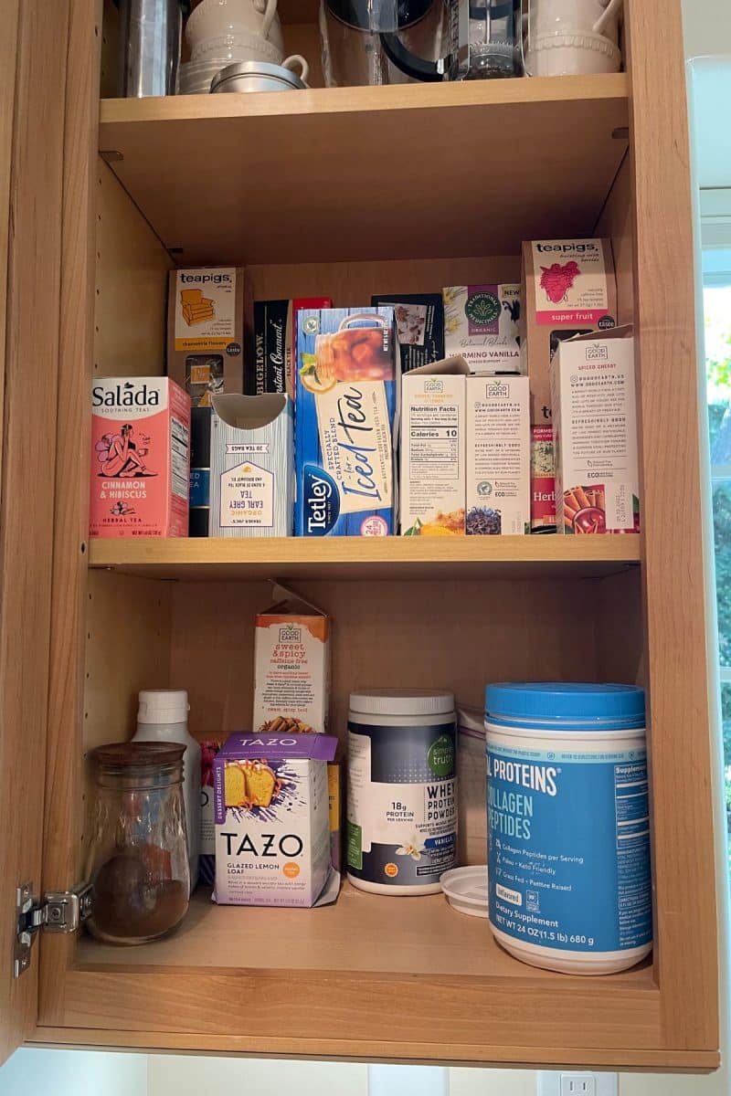 Tea cupboard willy nilly with boxes everywhere.