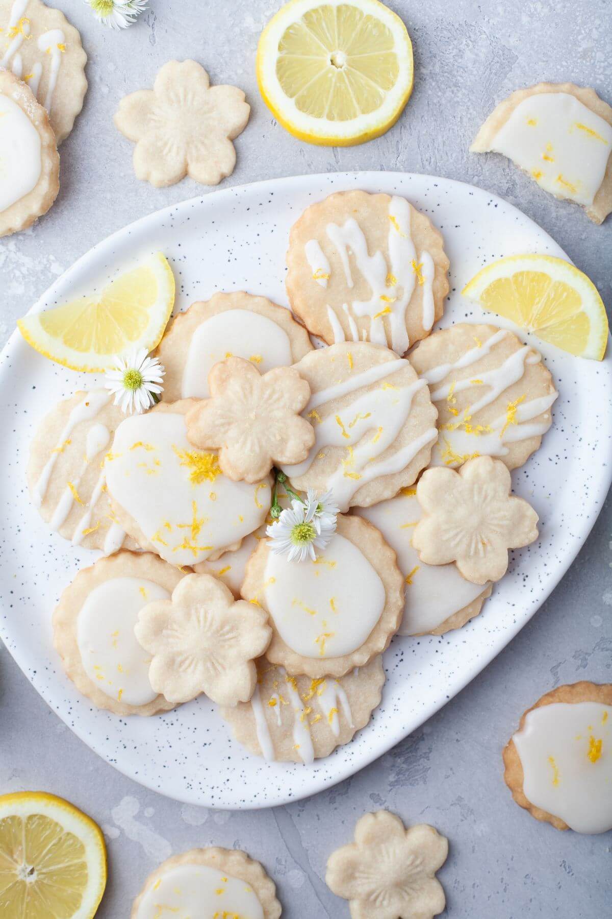 A cookie platter is surrounded by decorated cookies and lemons.