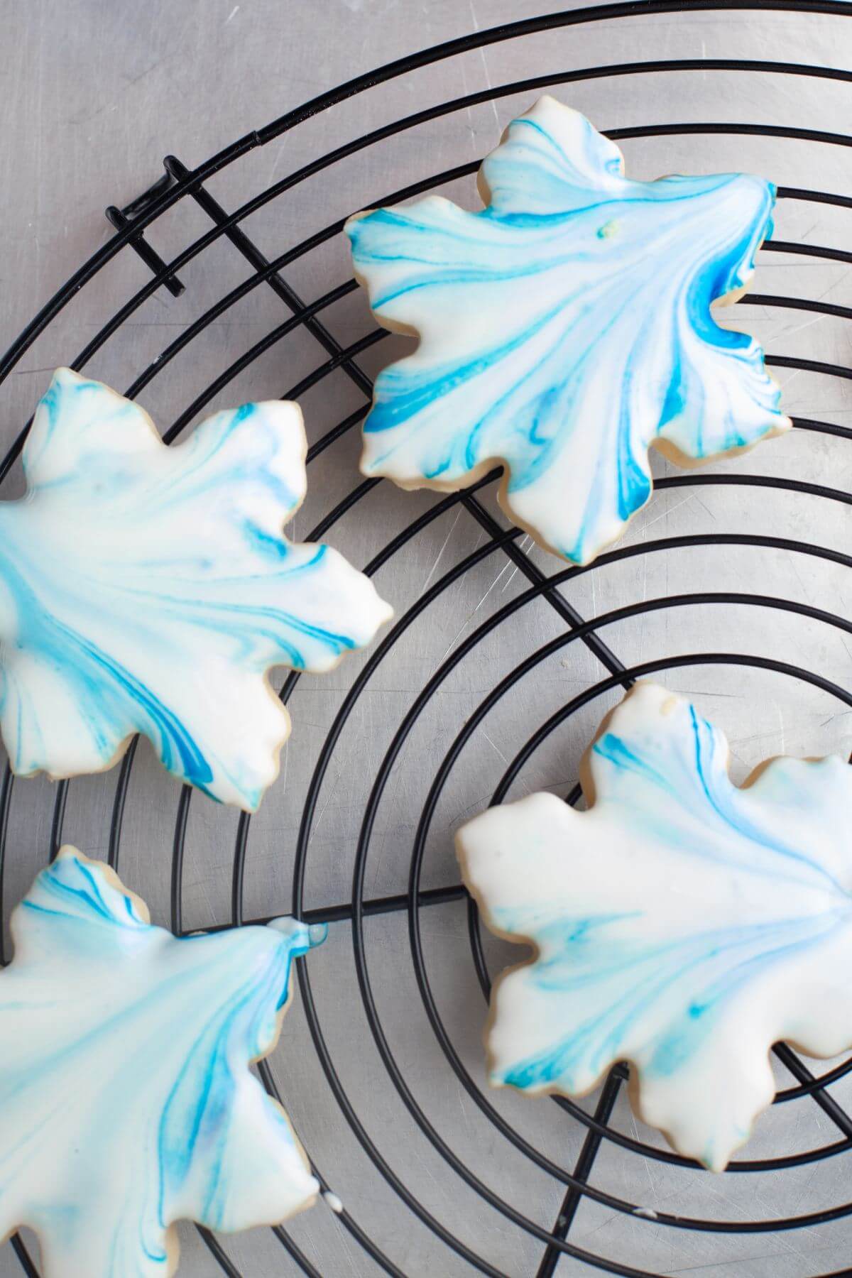 Blue marbled leaf cookies lay on wire rack.