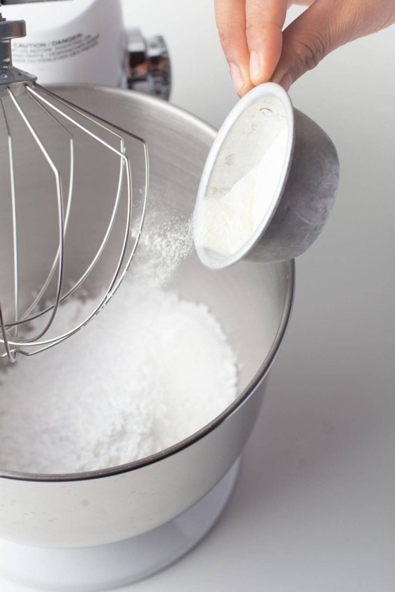 Someone is pouring flour into mixing bowl.