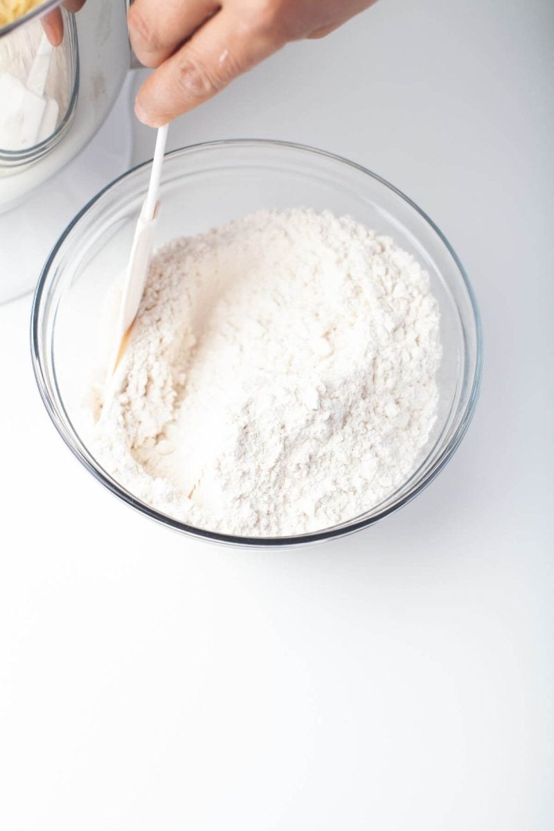 Someone is mixing dry ingredients together in bowl.