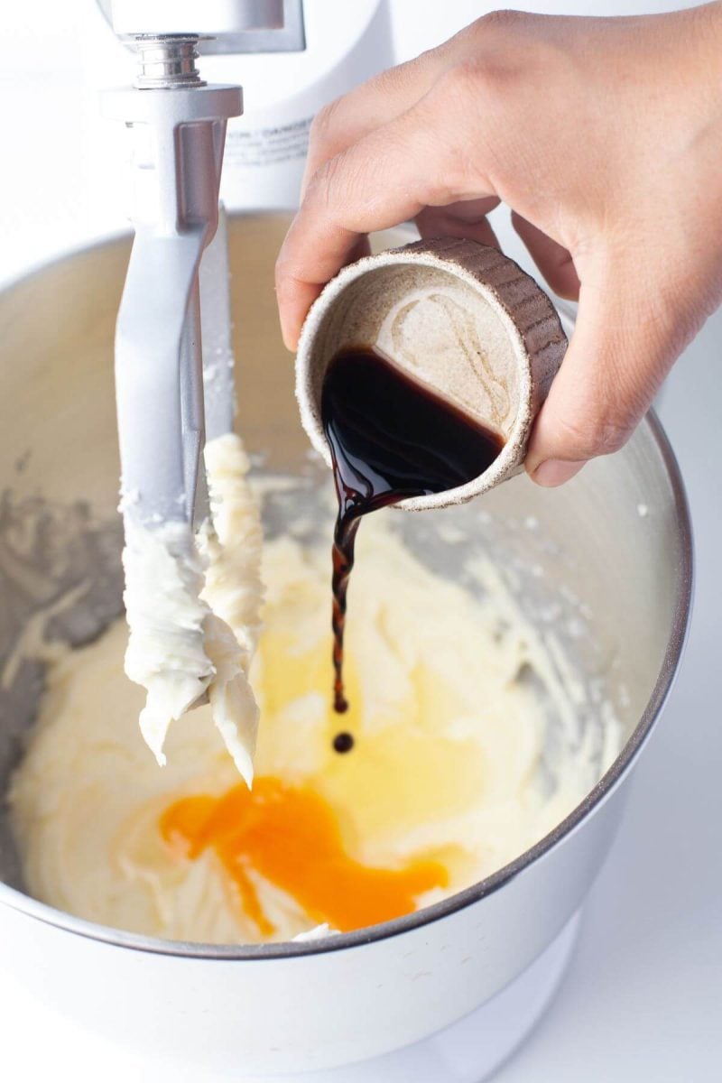 Someone is pouring a small amount of vanilla extract into bowl.