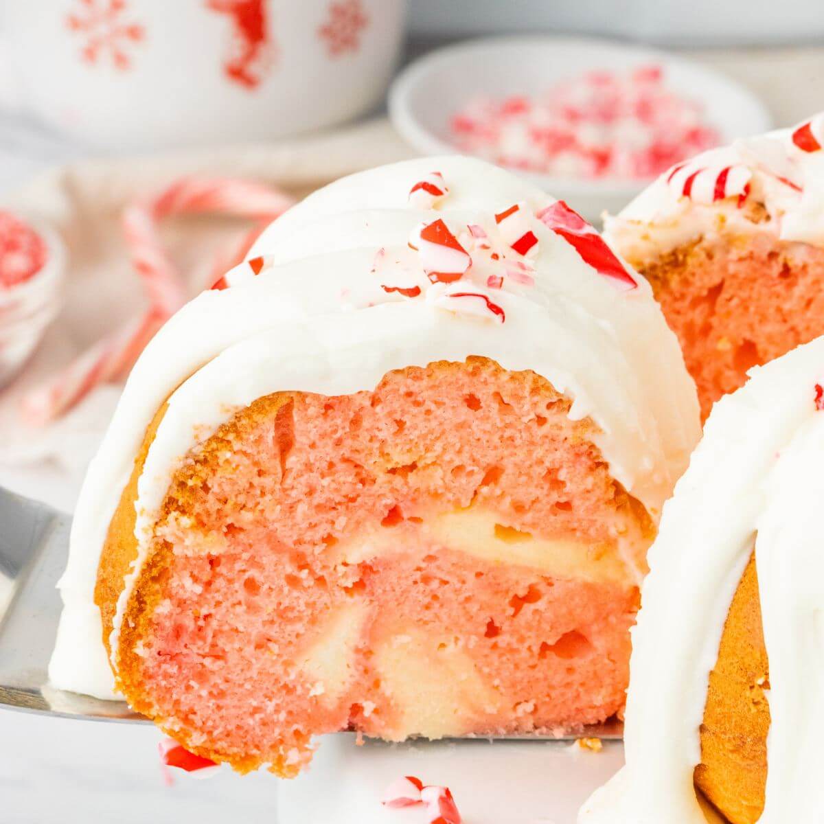 Peppermint Cake slice being taken out of whole cake.