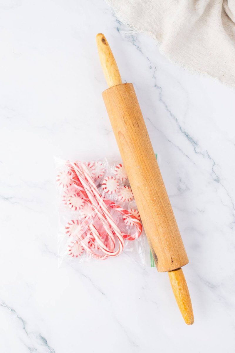 A rolling pin crushes candy canes and peppermints.
