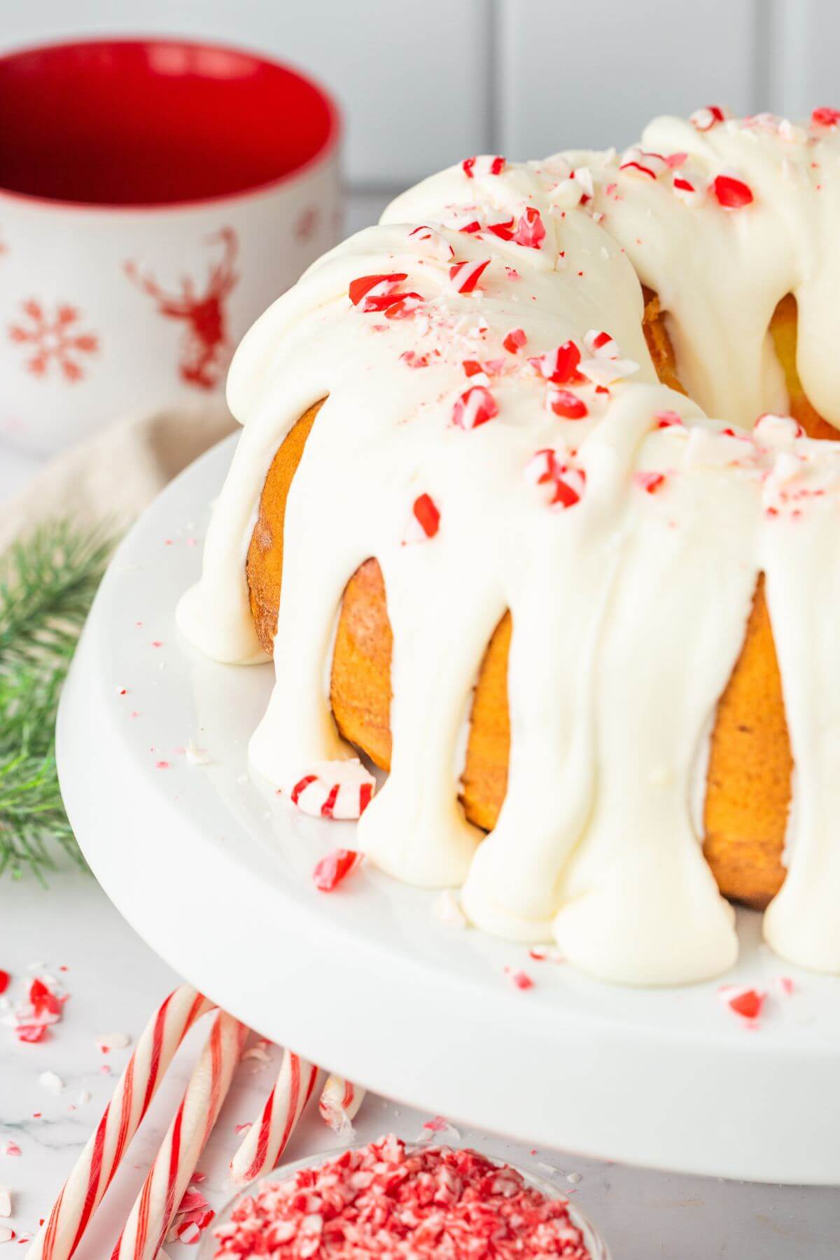 Peppermint Candy Cane Bundt Cake with Peppermint Cream Cheese Frosting shown on platter.