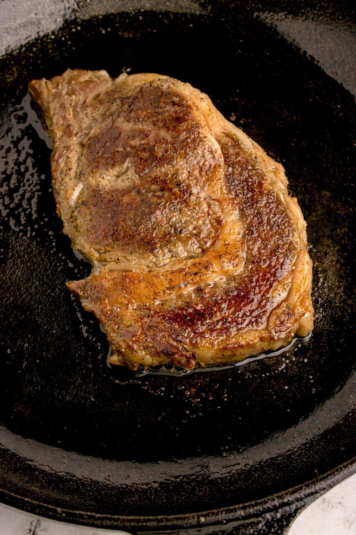 Steak searing in cast iron skillet.