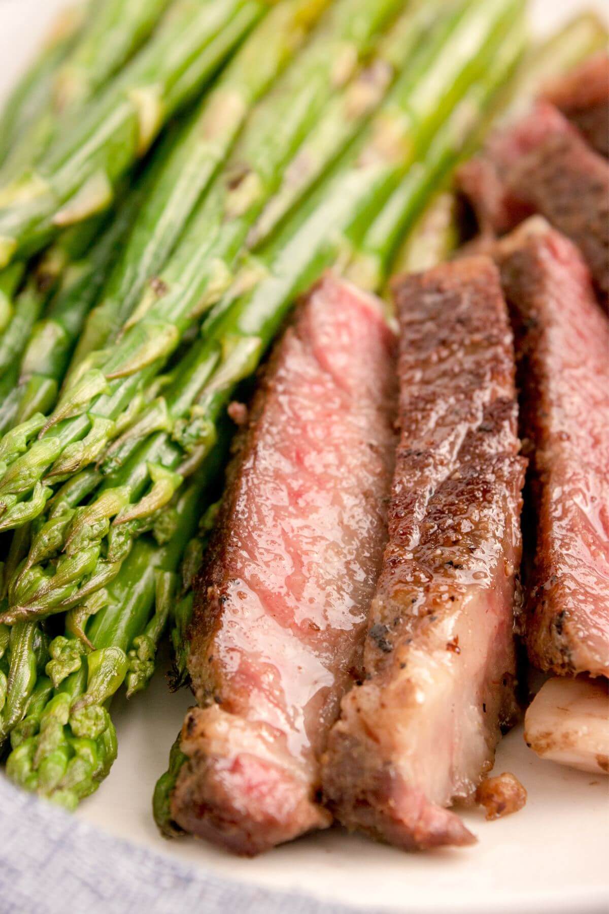 Sous Vide Ribeye by asparagus on plate.