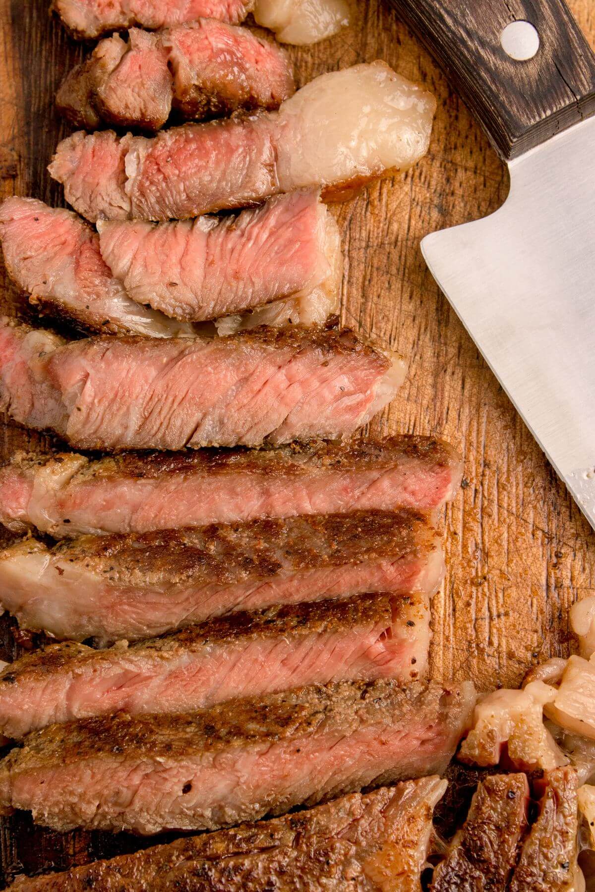 Sous Vide Ribeye pieces on cutting board by knife.