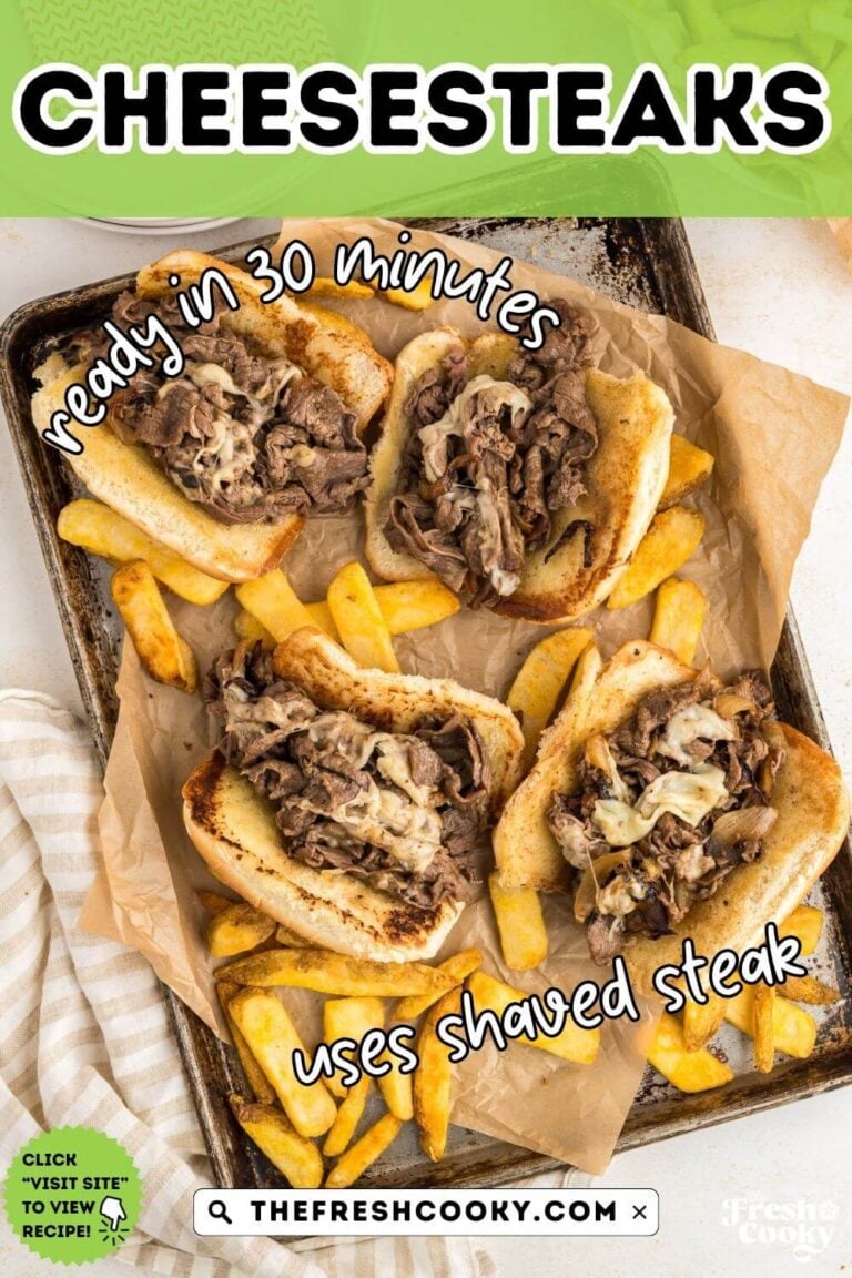 4 Cheesesteaks on a sheet pan surrounded by fries, for pinning.