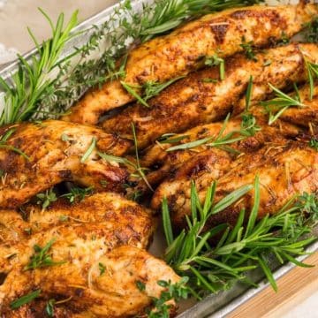 Multiple, air fryer turkey tenderloins juicy and on platter garnished with fresh rosemary.