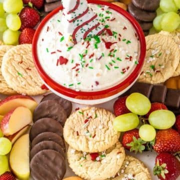 Bowl of dip centered in platter with cookies, fruit, chocolate dippers.