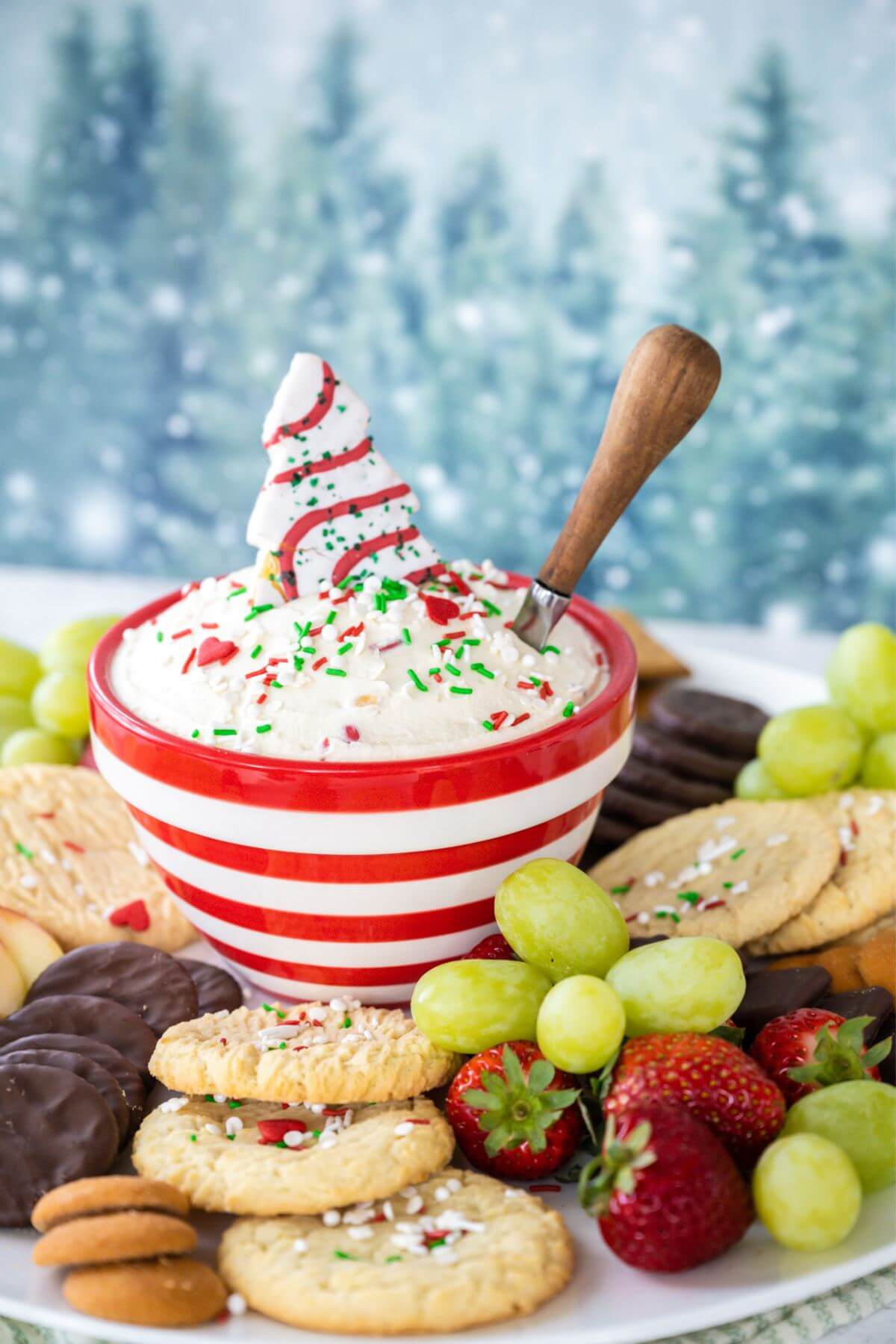 Side view of bowl of dip in center of platter with cookies, fruit, chocolate dippers.
