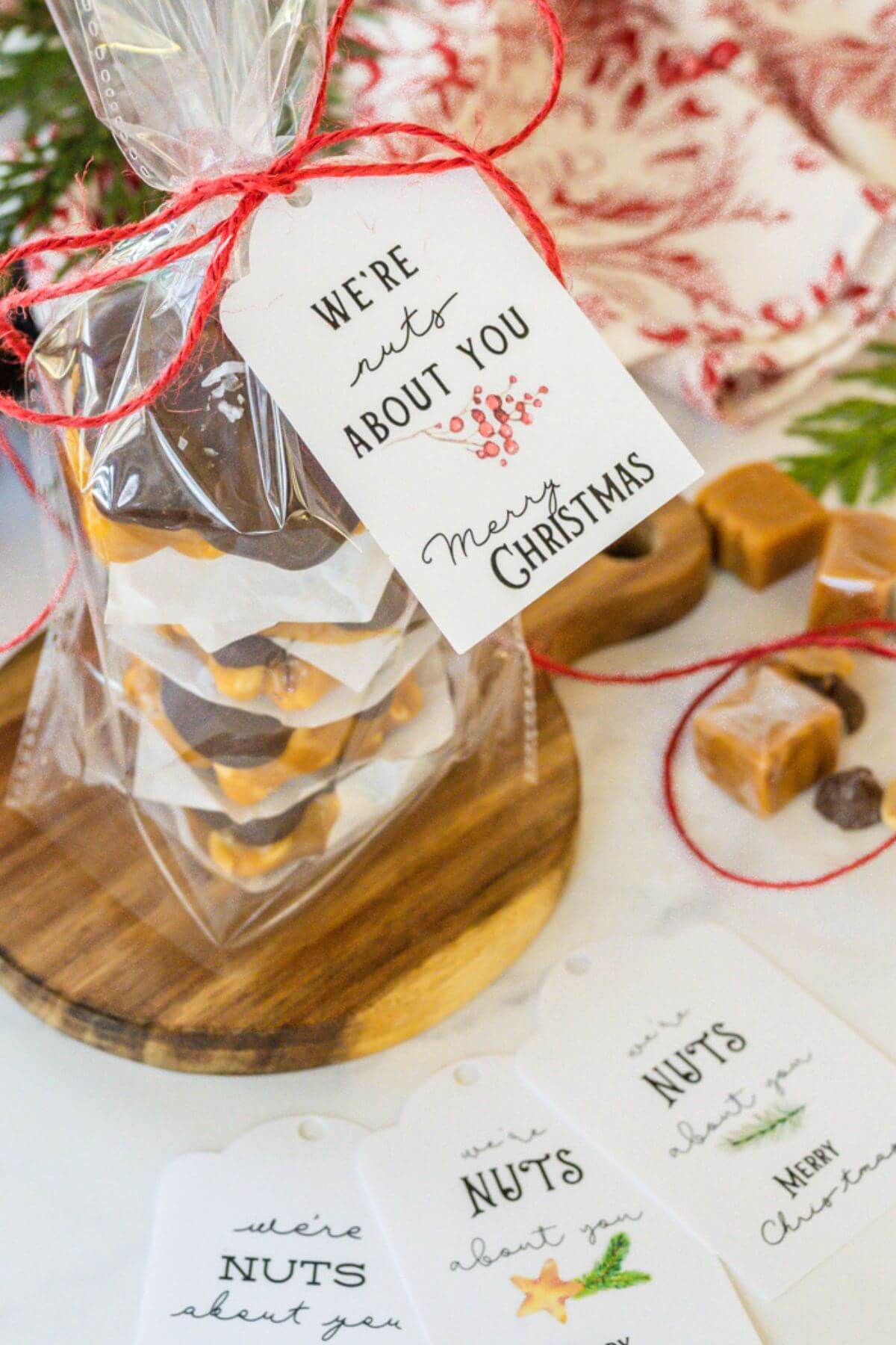 A clear gift bag showing the clusters is wrapped with holiday ribbon and tag that says, "We're nuts about you, Merry Christmas."
