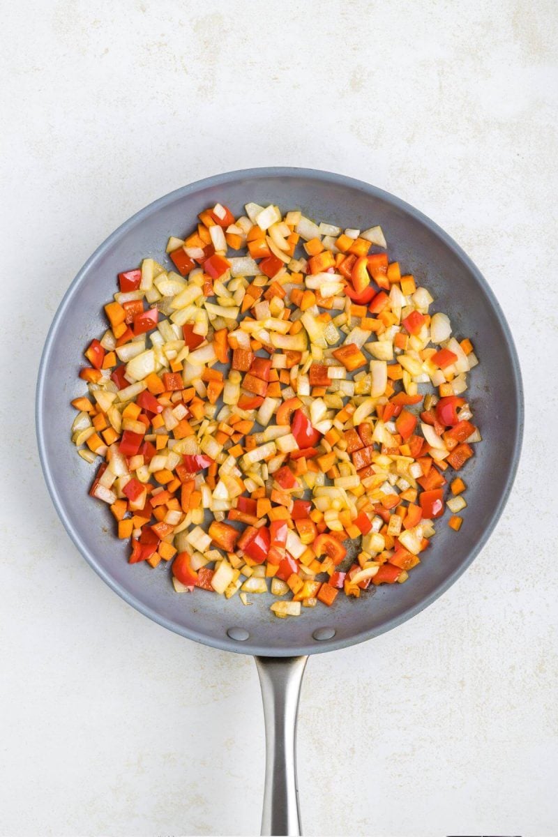 Peppers and onions are in a saucepan.