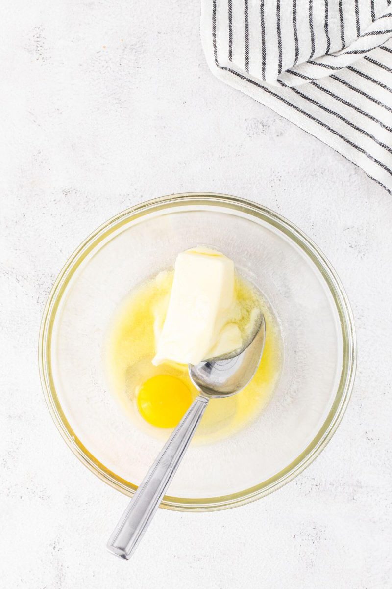 A bowl holds soft butter and a raw egg.