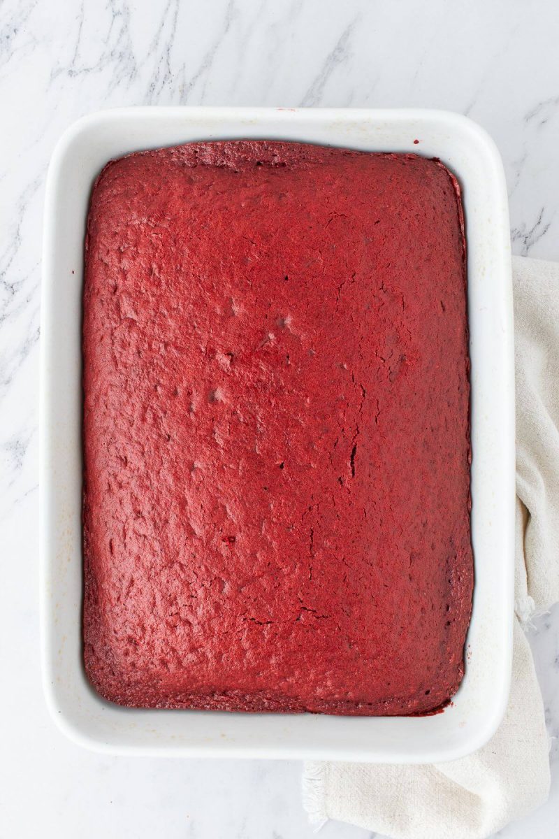 A cake pan is filled with red velvetbaked cake.