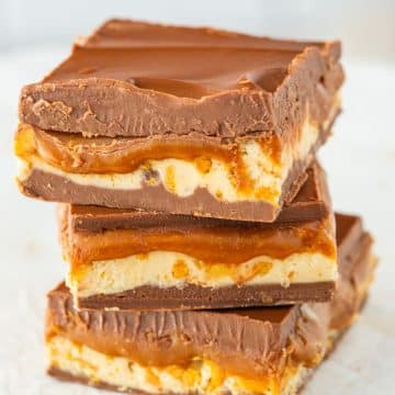 Three pieces of snickers fudge stacked on top of each other.