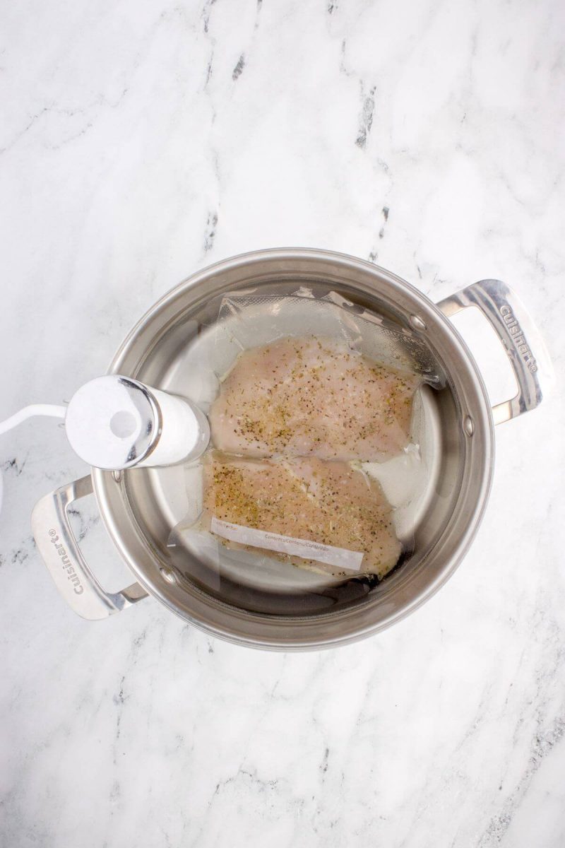 Two chicken breasts are in sous vide pan.