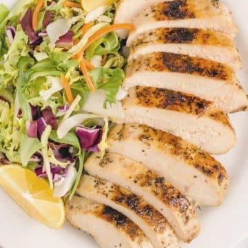 Sliced boneless chicken breast made sous vide with a salad on the side.