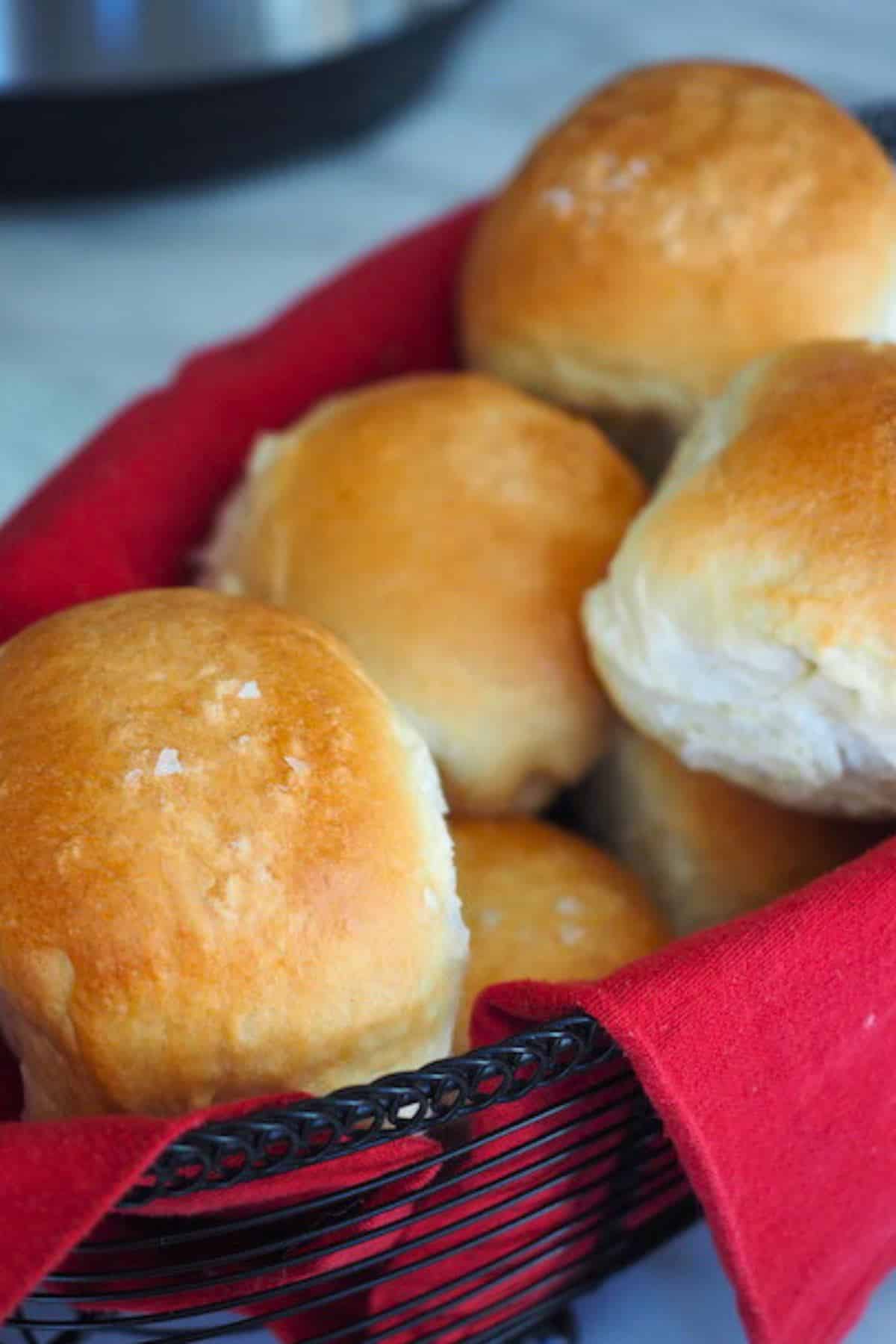 Yeast rolls in a basket with a red napkin.