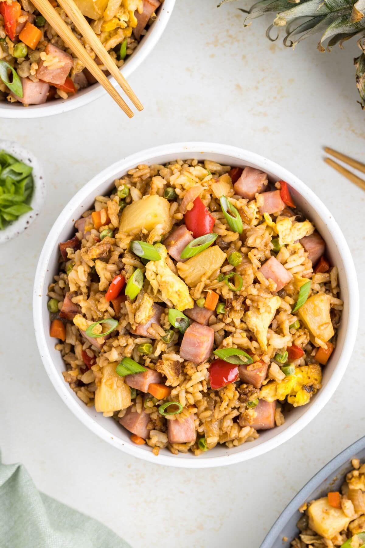 Bowls of fried rice with chopsticks are in a diagonal row.