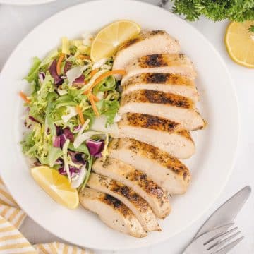 Sliced boneless chicken breast made sous vide with a salad on the side.