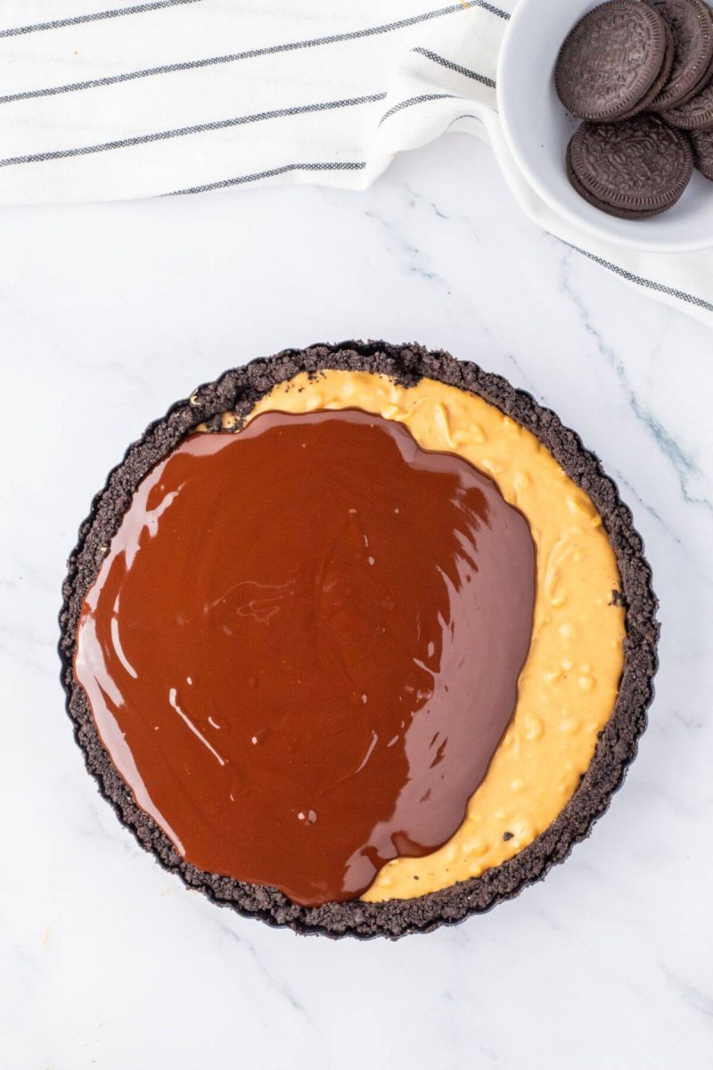 Spreading chocolate ganache on top of peanut butter filling. 
