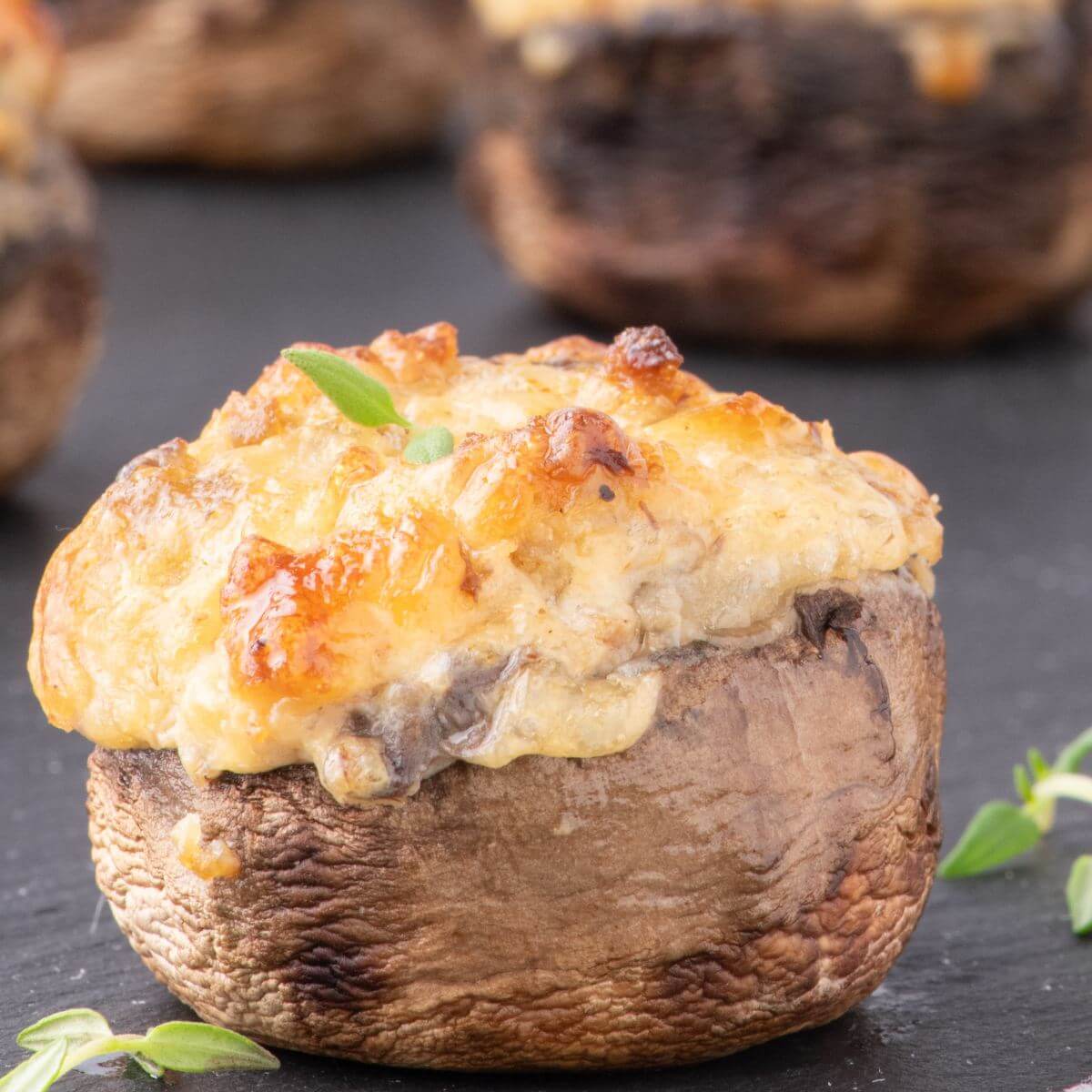 Fluffy, gooey cheese and sausage topping sits on a stuffed mushroom.